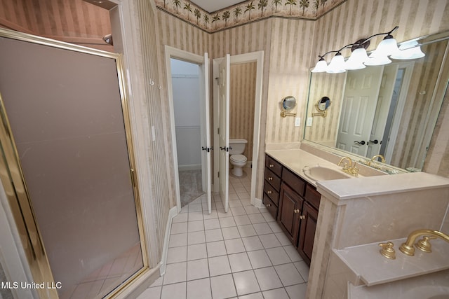 bathroom with vanity, toilet, tile patterned floors, and walk in shower