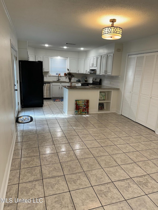 kitchen with white cabinetry, stainless steel appliances, a textured ceiling, and light tile patterned floors