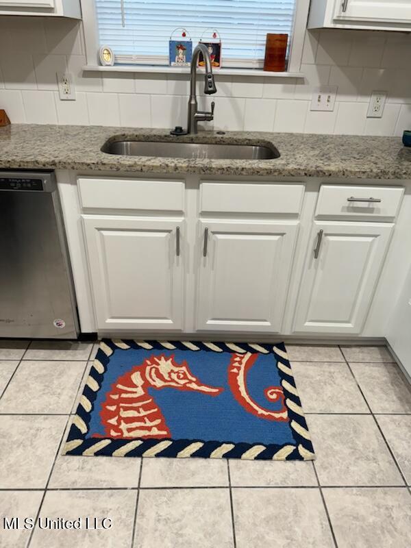 kitchen with white cabinets, light tile patterned flooring, sink, and dishwashing machine