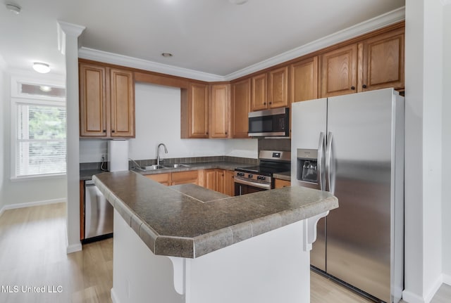 1515 E Beach Blvd Unit 132, Pass Christian, MS 39571 - kitchen with appliances with stainless steel finishes, a kitchen bar, light wood finished floors, brown cabinetry, and ornamental molding