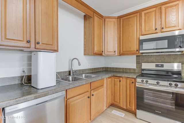 1515 E Beach Blvd Unit 132, Pass Christian, MS 39571 - kitchen featuring appliances with stainless steel finishes, tasteful backsplash, light wood finished floors, and dark countertops