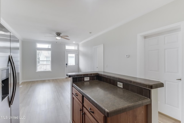 1515 E Beach Blvd Unit 132, Pass Christian, MS 39571 - kitchen with stainless steel refrigerator with ice dispenser, dark countertops, brown cabinetry, a ceiling fan, and a kitchen island