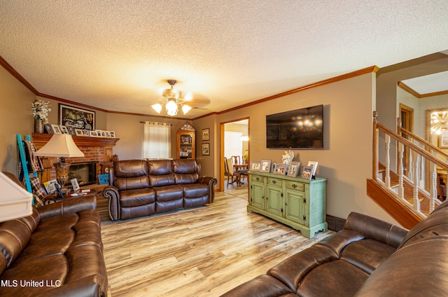 living room featuring light hardwood / wood-style floors, crown molding, a textured ceiling, and ceiling fan