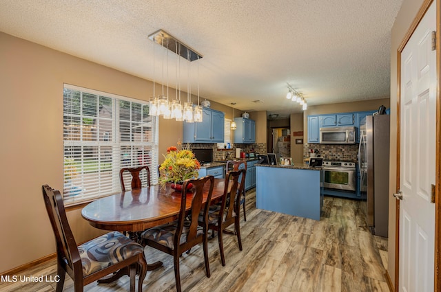 dining area with hardwood / wood-style floors and a textured ceiling