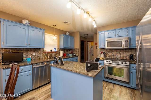 kitchen with stainless steel appliances, a textured ceiling, light hardwood / wood-style flooring, and blue cabinets