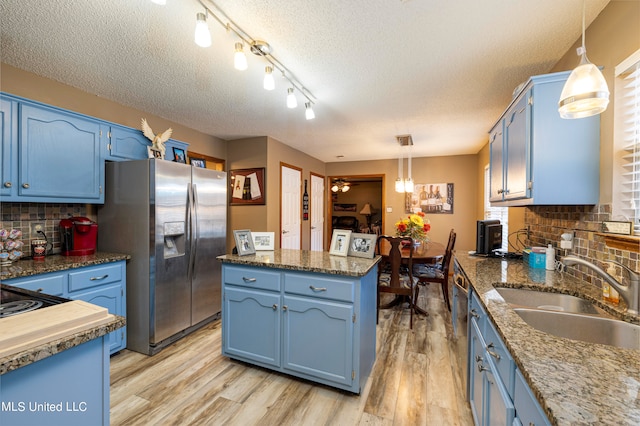 kitchen with appliances with stainless steel finishes, blue cabinets, and sink