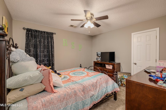 carpeted bedroom featuring a textured ceiling and ceiling fan