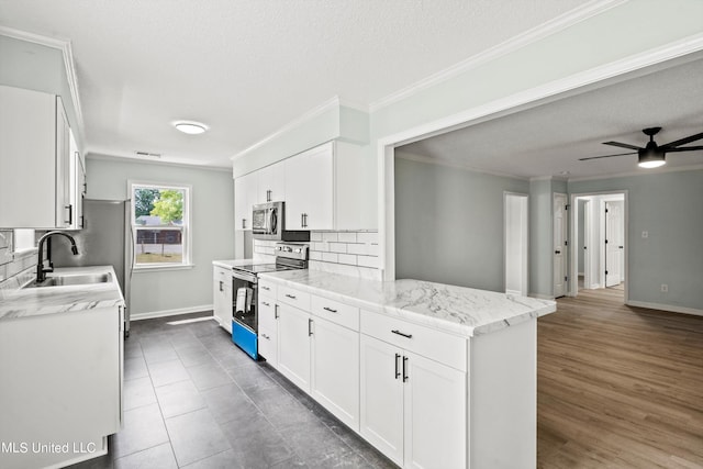 kitchen featuring white cabinets, backsplash, light stone countertops, sink, and stainless steel appliances