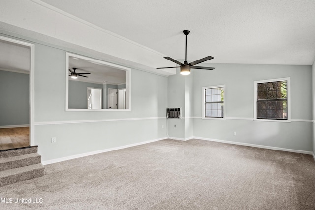 empty room featuring carpet floors, ceiling fan, and vaulted ceiling