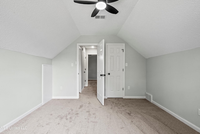 additional living space with light carpet, lofted ceiling, a textured ceiling, and ceiling fan