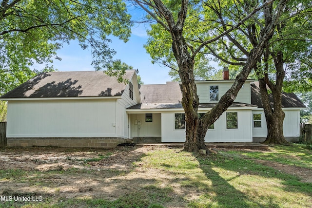 rear view of house featuring a yard