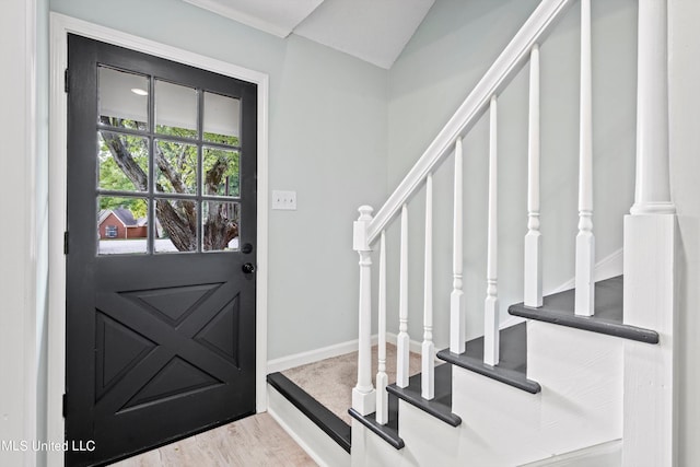 entryway with light hardwood / wood-style floors and vaulted ceiling