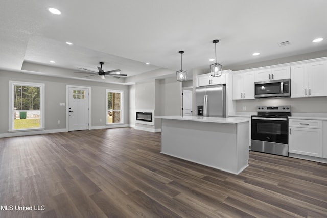 1457 Rue De Courmont, Gautier, MS 39553 - kitchen featuring appliances with stainless steel finishes, recessed lighting, dark wood finished floors, light countertops, and white cabinets
