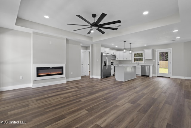 1457 Rue De Courmont, Gautier, MS 39553 - unfurnished living room with a glass covered fireplace, dark wood-type flooring, recessed lighting, and ceiling fan