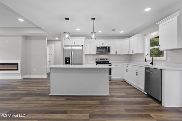 1457 Rue De Courmont, Gautier, MS 39553 - kitchen featuring stainless steel appliances, recessed lighting, a center island, white cabinets, and light countertops