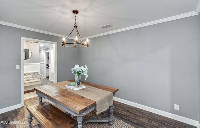 dining area with dark hardwood / wood-style flooring, crown molding, and a chandelier