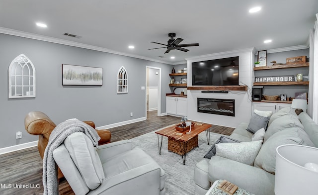 living room with dark wood-type flooring, ceiling fan, and crown molding