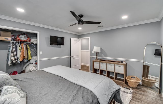 bedroom featuring crown molding, ceiling fan, wood-type flooring, and a closet