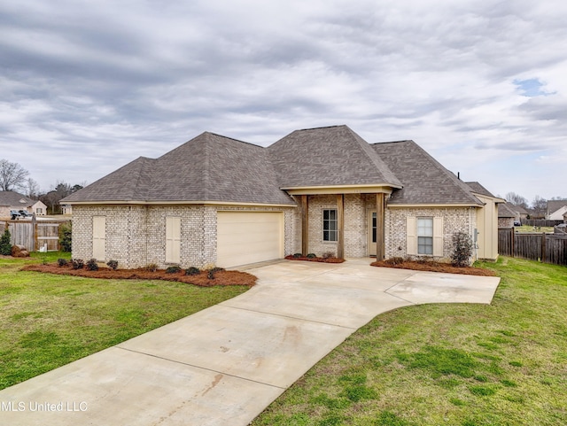 french provincial home with a front lawn and a garage