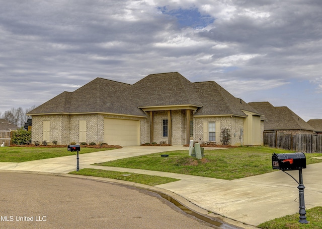 french country style house with a front yard and a garage