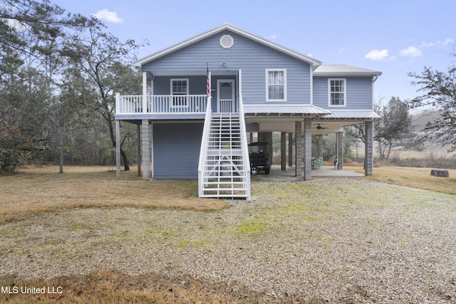 beach home with a carport, a front yard, and covered porch