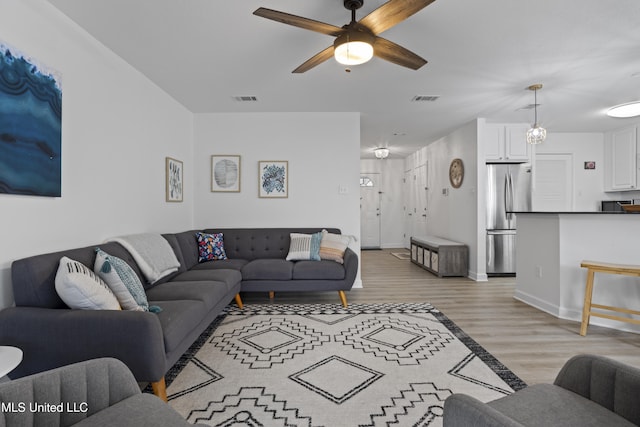 living room featuring ceiling fan and light hardwood / wood-style floors