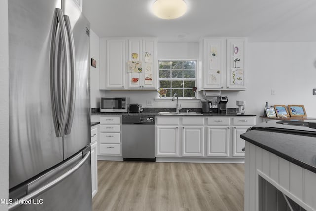 kitchen featuring sink, stainless steel appliances, light hardwood / wood-style floors, and white cabinets