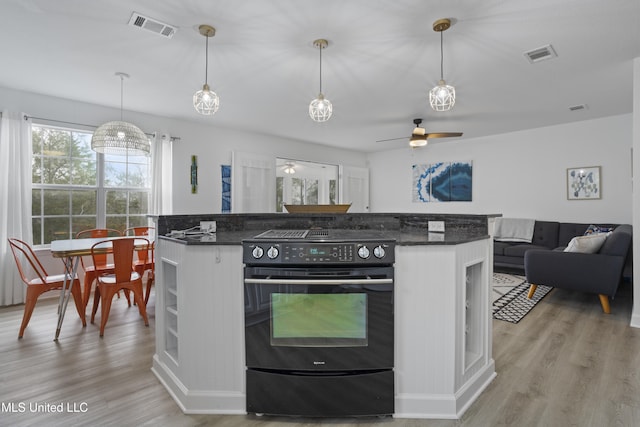 kitchen featuring pendant lighting, ceiling fan, black / electric stove, dark stone counters, and light wood-type flooring