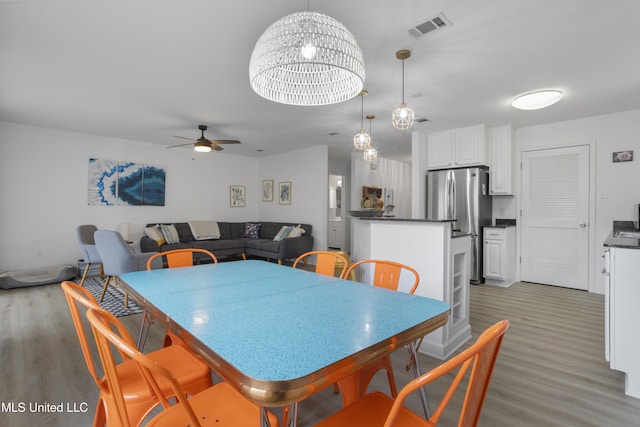 dining room with ceiling fan and light hardwood / wood-style flooring