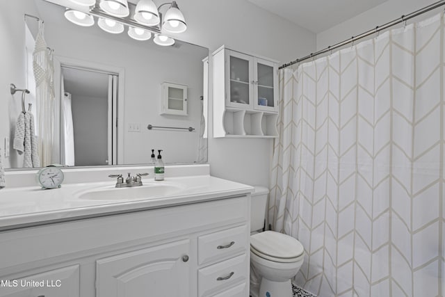 bathroom featuring vanity, curtained shower, and toilet