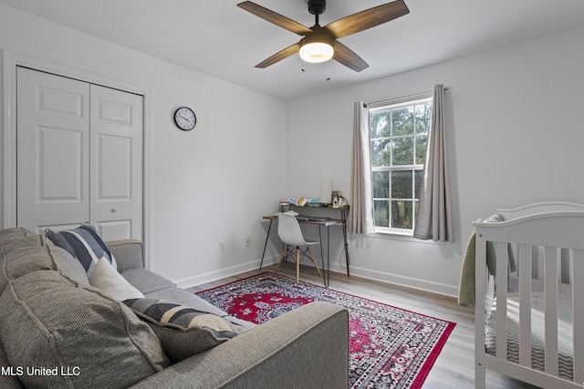 bedroom featuring ceiling fan, light wood-type flooring, and a closet