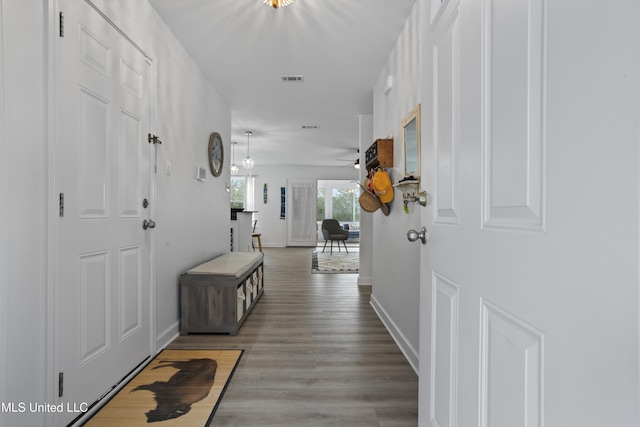 hall featuring an inviting chandelier and hardwood / wood-style floors