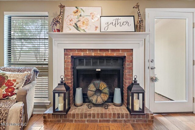 interior details featuring hardwood / wood-style floors and a brick fireplace