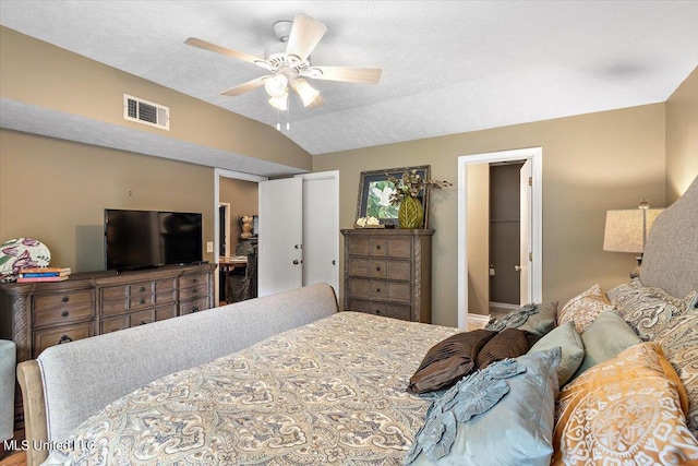 bedroom featuring a closet, a textured ceiling, vaulted ceiling, and ceiling fan