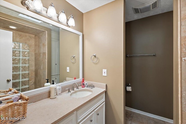 bathroom with vanity, a textured ceiling, and tile patterned flooring