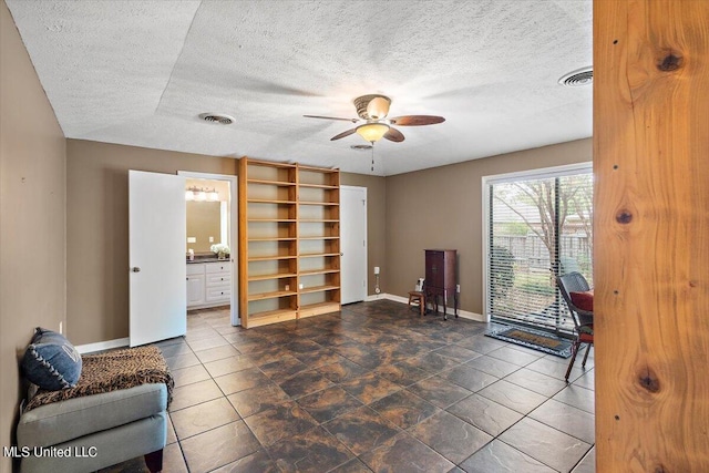 sitting room with a textured ceiling and ceiling fan