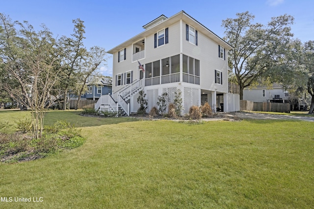 rear view of property with a sunroom and a yard