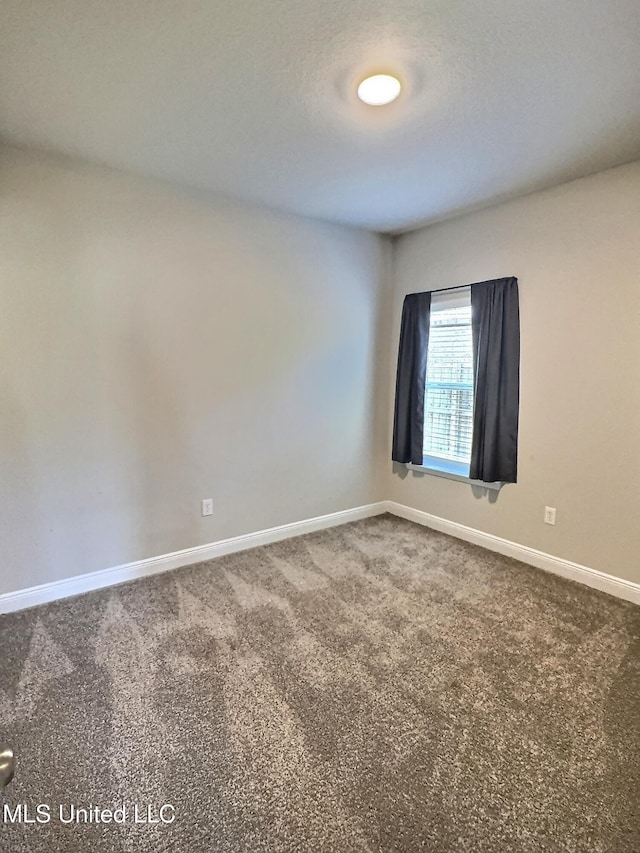 carpeted spare room featuring baseboards
