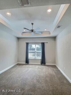carpeted empty room with recessed lighting, a raised ceiling, baseboards, and ceiling fan