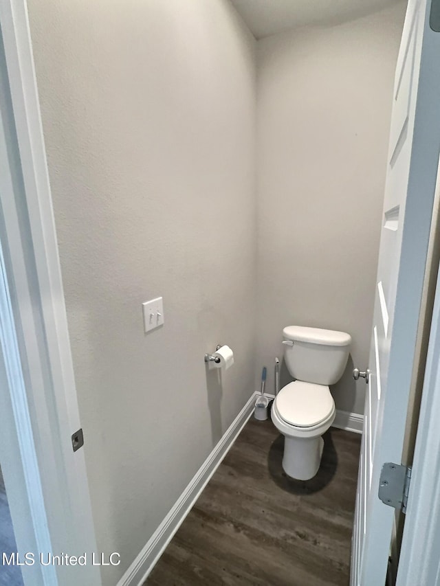 bathroom with baseboards, toilet, and wood finished floors