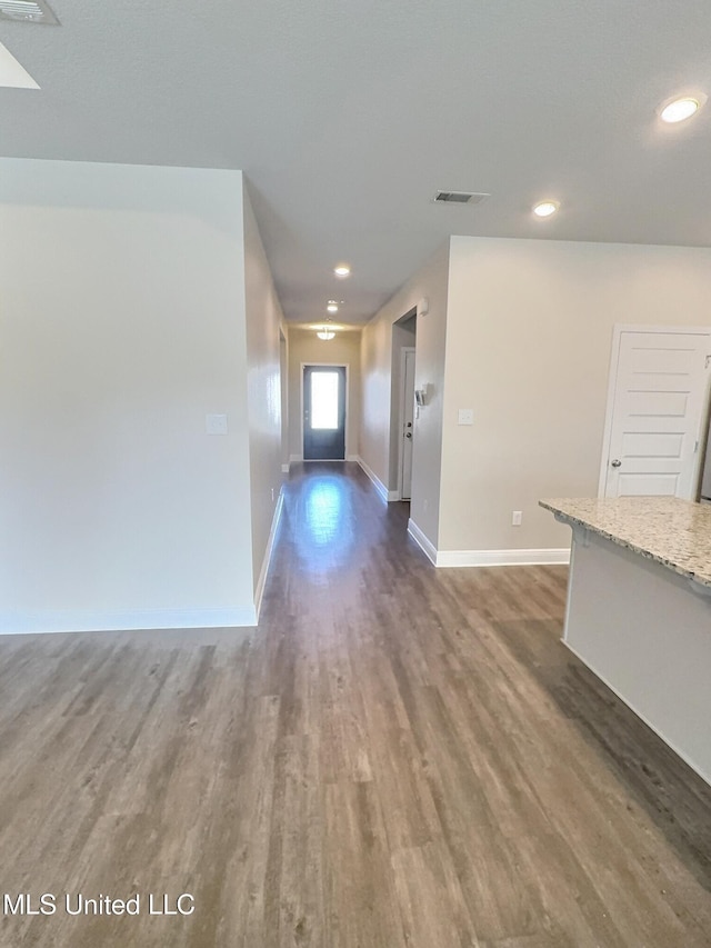 interior space featuring baseboards, recessed lighting, wood finished floors, and visible vents