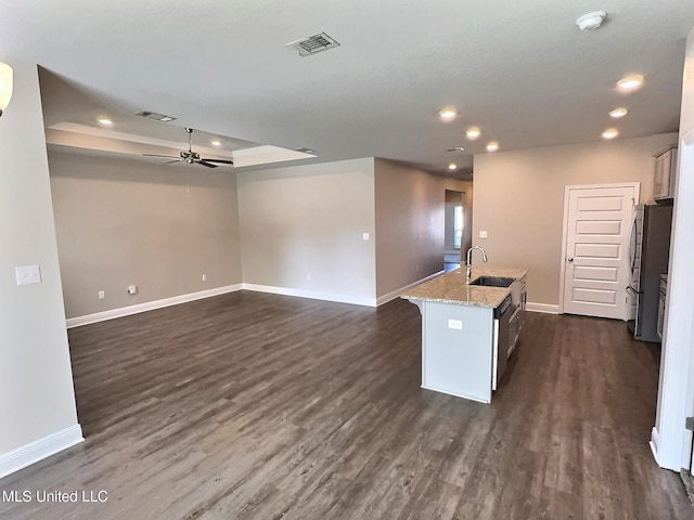 kitchen featuring ceiling fan, a sink, freestanding refrigerator, baseboards, and visible vents