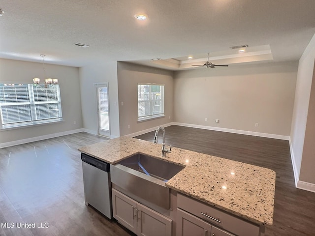 kitchen with open floor plan, dark wood-style flooring, ceiling fan with notable chandelier, and dishwasher
