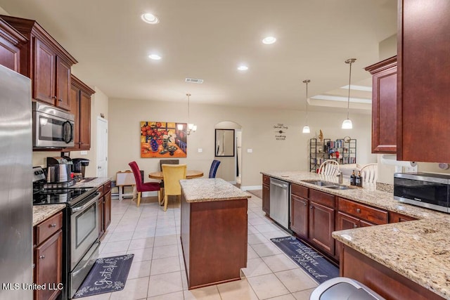 kitchen featuring visible vents, a sink, decorative light fixtures, and stainless steel appliances