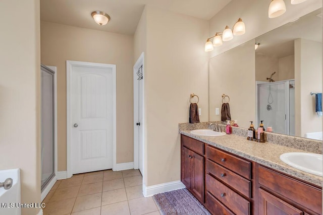 bathroom with double vanity, tile patterned floors, a sink, and a stall shower