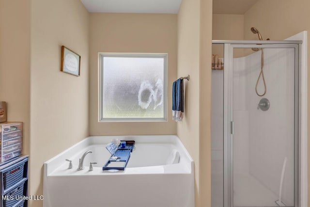 bathroom with a bath and a stall shower