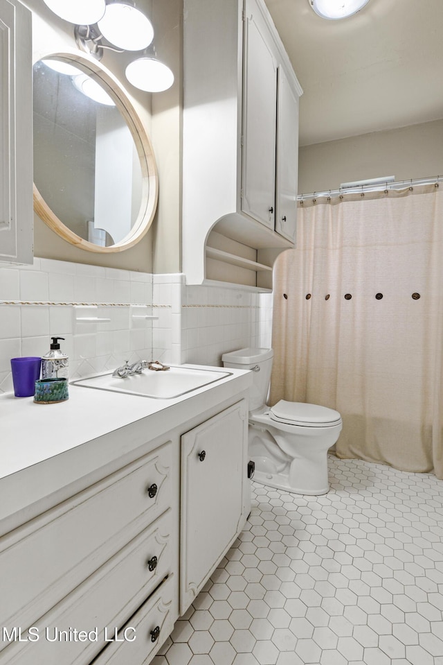 2418 24th Ave, Meridian, MS 39301 - full bathroom featuring vanity, toilet, tile walls, and curtained shower