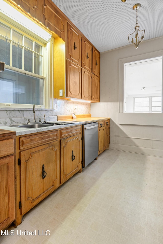 2418 24th Ave, Meridian, MS 39301 - kitchen featuring dishwasher, brown cabinetry, light countertops, a sink, and light floors
