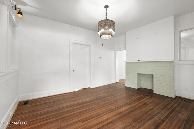 2418 24th Ave, Meridian, MS 39301 - unfurnished living room featuring wood finished floors, a brick fireplace, a chandelier, and baseboards