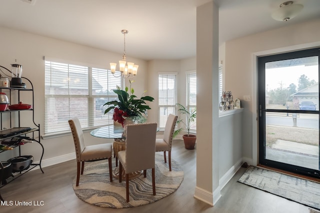 dining space featuring hardwood / wood-style flooring and a notable chandelier